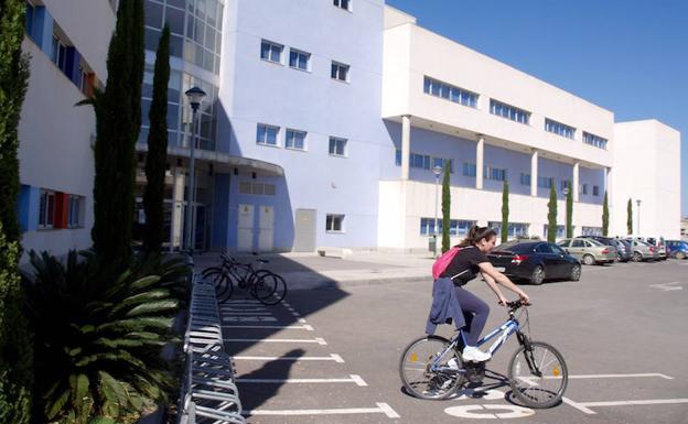 Una alumna sale en bicicleta del campus universitario de San Javier.