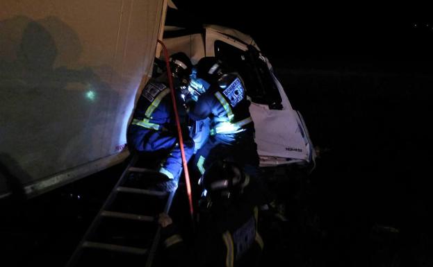 Los bomberos sacan de la cabina a uno de los heridos.