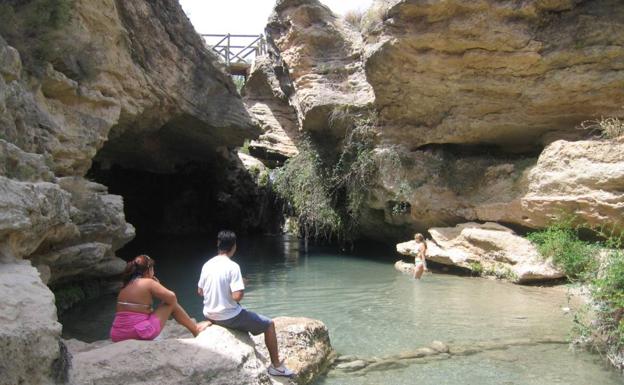 Varias personas disfrutan en el paraje del Salto del Usero.