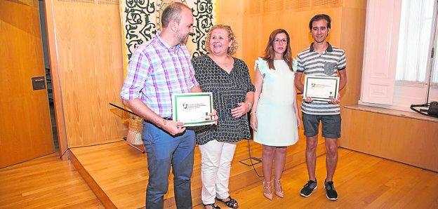 Dos de los participantes en el campus, con su diploma.