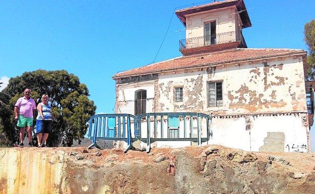 Dos vecinos, junto a la histórica casa de don Zenón y el muro que deberá ser reconstruido para evitar accidentes.