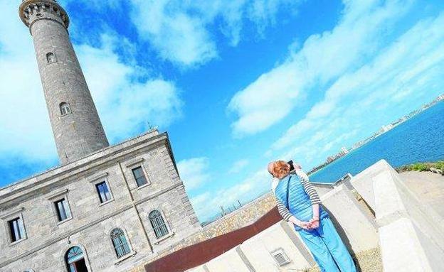 Dos turistas toman fotos de La Manga desde el mirador que hay junto al faro.
