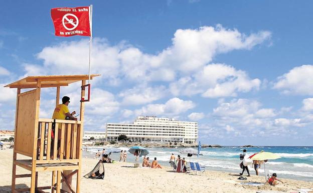 Bandera roja ondeando en el puesto de vigilancia de la playa de Galúa, en La Manga./Pablo Sánchez / AGM