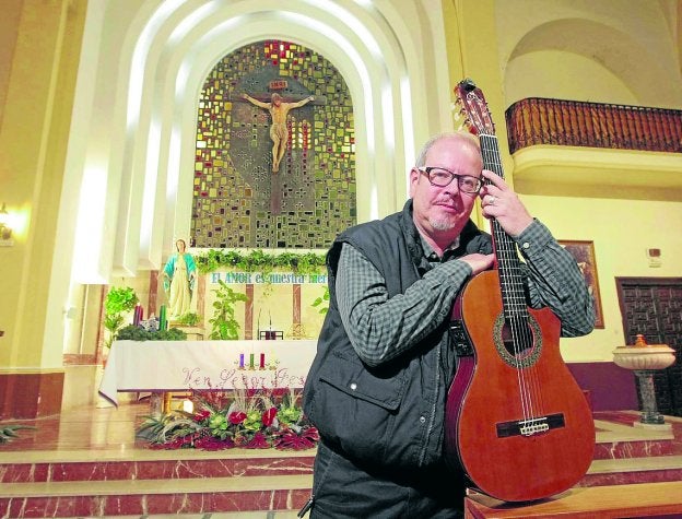 Kini Ferrando, apoyado en su guitarra, ante el altar mayor de San Diego.