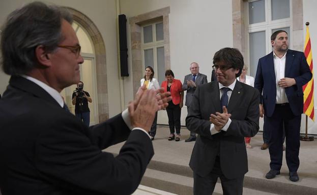 Mas (i) aplaude a Puigdemont.