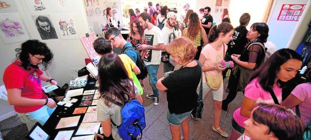 Amantes de los cómics visitan el interior de la carpa con los dibujantes, ayer, en el 'Cómic Day'.