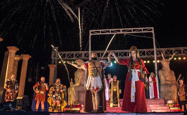 Los dos esposos sonríen al público al consumarse la boda, con el cortejo y los fuegos artificiales a sus espaldas. /José María Rodríguez / AGM
