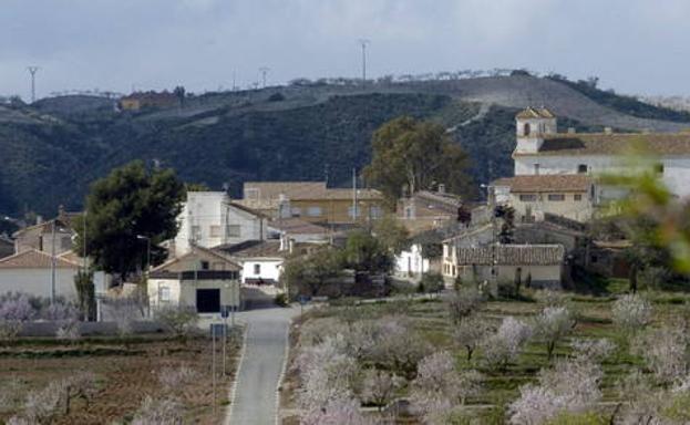 Las casas de Campo López se vislumbran entre bancales de almendros./