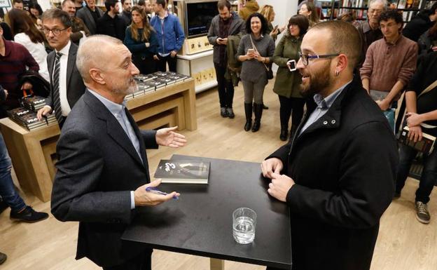 Arturo Pérez-Reverte conversa con un lector en la firma de libros este viernes en Murcia. /Edu Botella / AGM