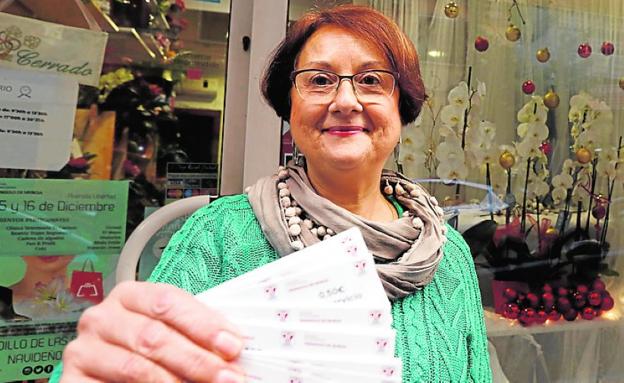 Carmen Piñero, con los tiques descuento para que los clientes utilicen el taxi./Edu Botella / AGM