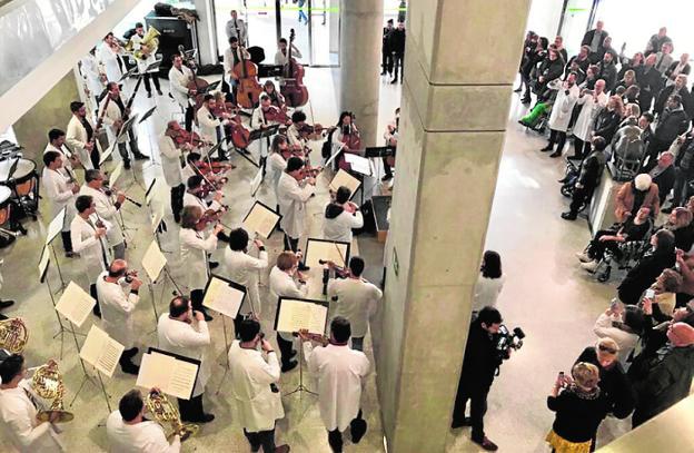 Los músicos de la OSRM, ataviados con batas blancas, tocan en el vestíbulo del Reina Sofía en Murcia./CARM