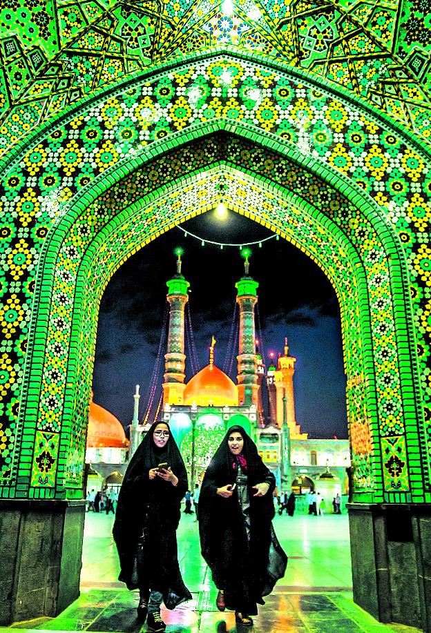 Lugares santos. Dos mujeres abandonan entre azulejos de colores la monumental plaza de Hazrat Masoumeh, un emblema para los musulmanes chiíes./Sergio García