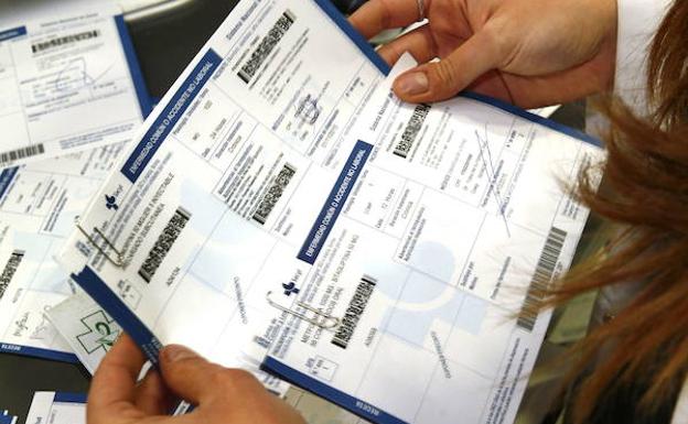 Una doctora revisa varias recetas médicas./Avelino Gómez