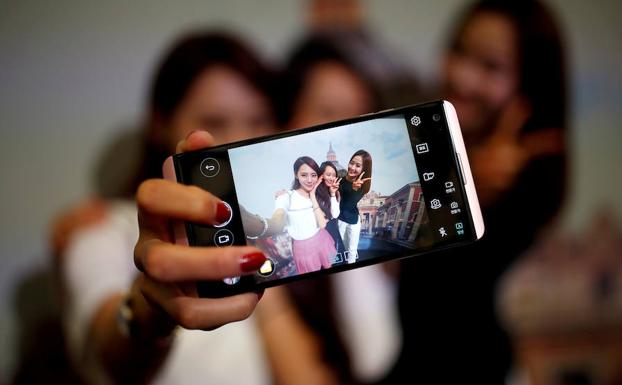 Tres mujeres se fotografían con su teléfono. /Kim Hong-Ji (Reuters)