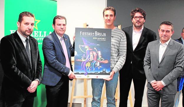 El ganador del concurso (c), Rubén Lucas, posando con el cartel./Ayto.