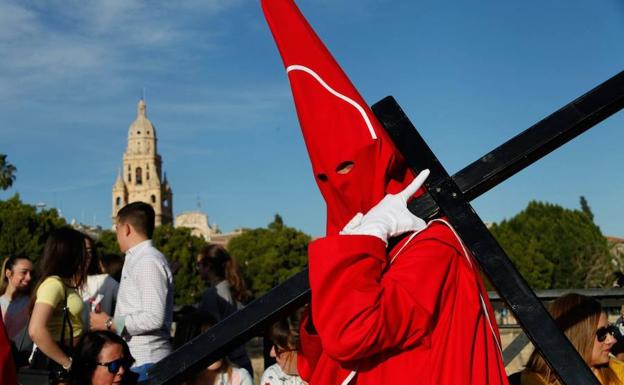 Un nazareno de los 'coloraos', durante la procesión de este miércoles, con la catedral de Murcia al fondo./J.C. Caval / AGM