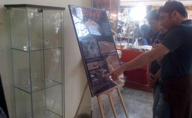 Un padre y un hijo, mirando el cartel explicativo de los meteoritos, y al lado, los fragmentos, de entre 5 y 15 gramos. /P.S.