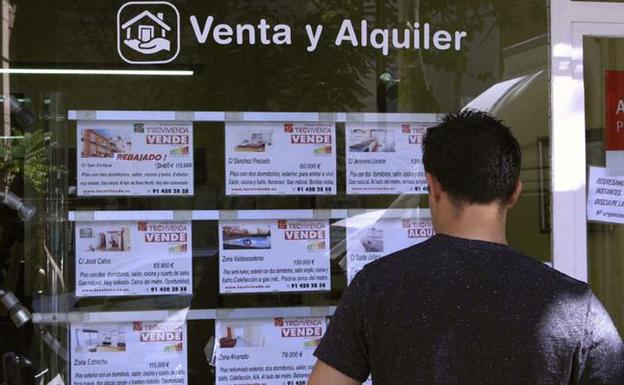 Un joven busca piso entre las ofertas de una inmobiliaria /EFE
