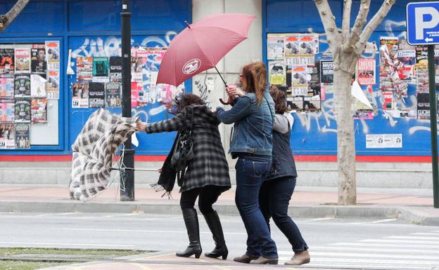 Tres mujeres intentan combatir el viento, en una fotografía de archivo./LV