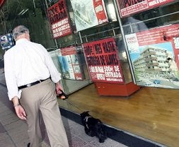 Escaparate con carteles de pisos en venta. / V. VICENS / AGM/