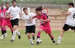El jugador del Lorca Zazo intenta regatear a varios jugadores del Alfaro. / FERNANDO DÍAZ/