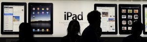 Un grupo de personas mira en una pantalla gigante las características y prestaciones de los nuevos iPad de Apple, que ayer se pusieron a la venta en España. :: AFP/