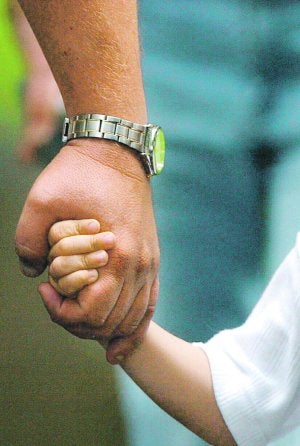 Un padre estrecha la mano de su hijo en una fotografía de archivo. ::
AP/