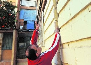 Rafael, vecino de La Paz, mete la mano en una grieta para mostrar el desplazamiento de los bloques. :: G. CARRIÓN/