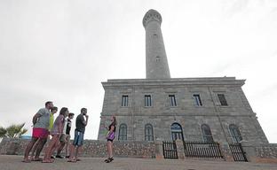 Un grupo de visitantes atiende a una guía turística, momentos antes de comenzar su recorrido por el Faro de Cabo de Palos. Seis visitantes, en la terraza del faro./ANTONIO GIL / AGM