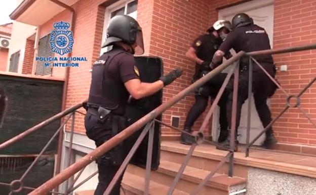 Agents of the National Police enter one of the houses of the organization dedicated to the falsification of asylum seekers' cards.