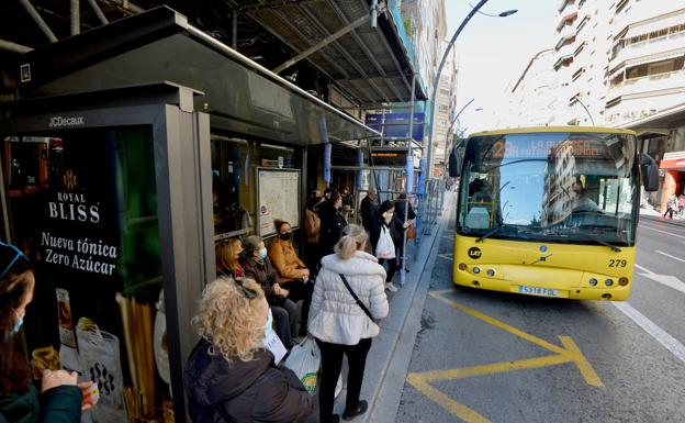 Travelers at a stop on Gran Vía;  below, the new image of Movibus buses. 