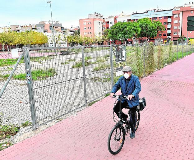 A neighbor passes by the site where the construction of the Santiago y Zaraíche (Murcia) health center has been planned for two decades. 