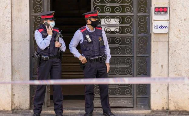 Two Mossos guard the entrance of the security company. 