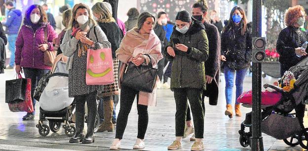 A group of people, most of them wearing masks, wait to cross a pedestrian crossing in Murcia, in an image taken yesterday. 