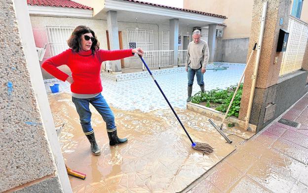 Residents of Los Alcázares affected by floods clean the entrance to their home in 2020. 