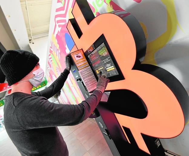 A young man is interested in an ATM that allows him to acquire Bitcoin in Carrefour Zaraíche, in Murcia. 