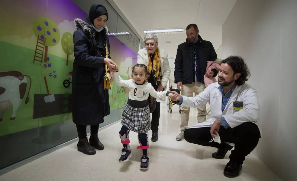 Nour walks down a corridor in La Arrixaca accompanied by her mother, Miriam Safiri;  Carmen Fernández, Caritas volunteer;  Abdelkarm El Maataqui (her uncle), and César Salceso, head of the Children's Orthopedic Surgery Unit. 