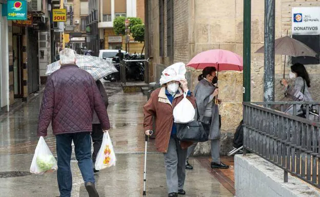 Several people protect themselves from the rain, in a file image.