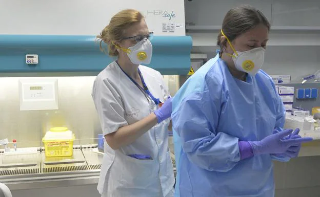 A health worker helps another to put on the protective equipment in the Microbiology service of La Arrixaca. 