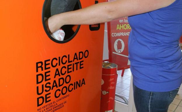 A woman recycles used oil in a container, in a file image.