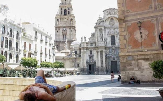 A man lies down in the shade on a hot day, in a file image.