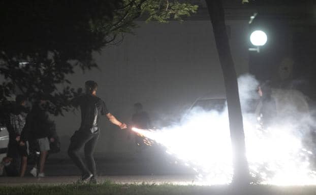 A young man throws a flare during last night's acts of vandalism in Cartagena.
