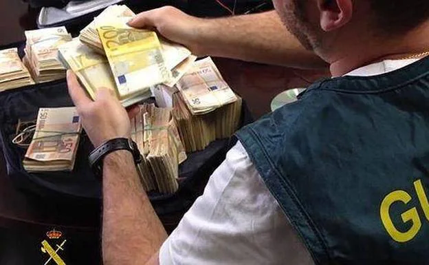 An agent of the Civil Guard, with several bundles of bills.