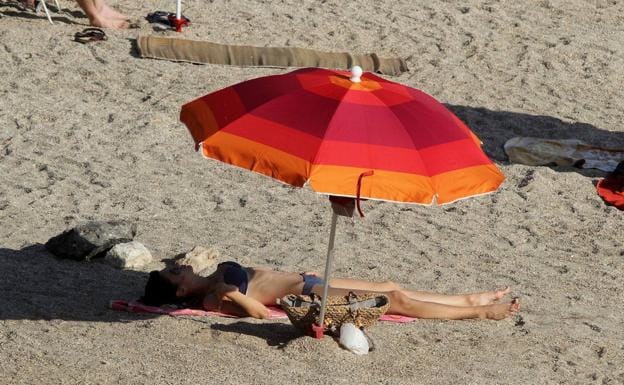 A woman sunbathes on the beach, in a file image. 