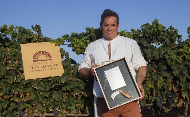 Jorge Sanz poses with his plaque as honorary grape harvester for Pla i Llevant Majorcan wines.