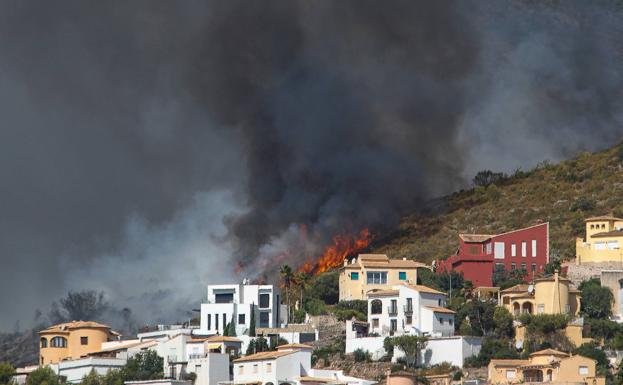 The flames of the fire in the Vall d'Ebo advance towards a housing area in the Atzubia.