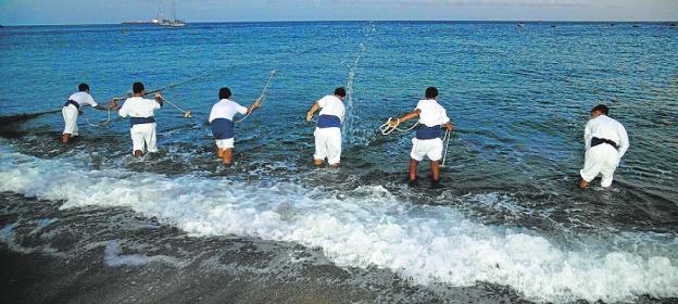 Six men throw their nets into the sea during the performance on this Mediterranean beach.