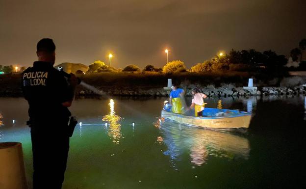 An agent lights the boat with the two alleged poachers in the Venziola de La Manga channel.