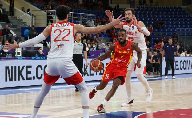 Lorenzo Brown, between two rivals of the Turkish national team.