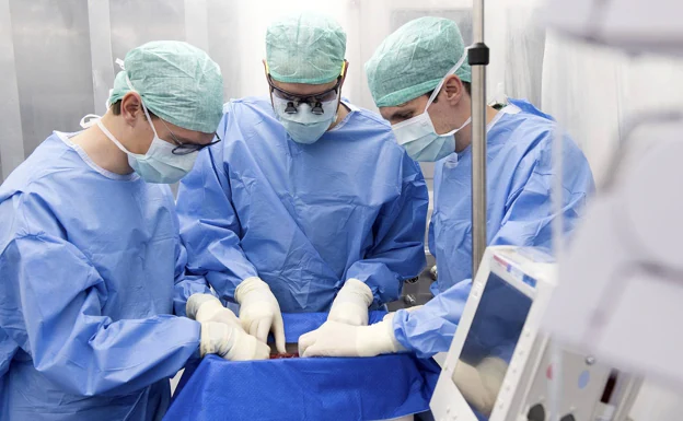A group of surgeons prepare to transplant a liver.
